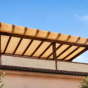 Telo ombreggiante beige su misura installato su pergola in legno con bordatura e occhielli