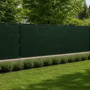 Telo ombreggiante verde scuro con occhielli installato su recinzione per privacy e ombra 90%