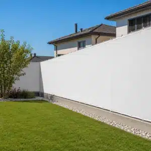 Telo ombreggiante bianco su misura installato su recinzione da giardino con bordatura e occhielli