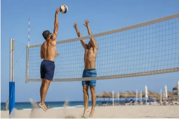 Giocatori di beach volley in azione davanti a una rete regolamentare.